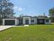 Modern home featuring a well manicured lawn, two car garage, and a striking front door at 42200 Chinaberry St, Eustis, FL 32736