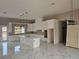 Bright kitchen boasts white cabinets, quartz countertops, an island and modern pendant lighting at 42200 Chinaberry St, Eustis, FL 32736