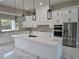 Bright kitchen with marble floors, white cabinets, island, and stainless steel appliances at 42200 Chinaberry St, Eustis, FL 32736