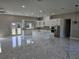 Bright kitchen with marble floors, white cabinets, island, and stainless steel appliances at 42200 Chinaberry St, Eustis, FL 32736