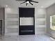 Living room with marble floors, fireplace, built in shelving, and modern ceiling fan at 42200 Chinaberry St, Eustis, FL 32736