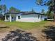 Back of house featuring a covered patio and expansive backyard surrounded by mature trees at 42200 Chinaberry St, Eustis, FL 32736