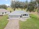 An aerial view showcases a house with a paver driveway and beautifully landscaped yard at 5004 Saint Andrews Arc, Leesburg, FL 34748