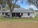 Home's exterior showcasing a screened patio and yard at 5004 Saint Andrews Arc, Leesburg, FL 34748