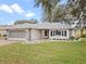 Single-story house with stone accents, screened garage, and a landscaped yard at 5004 Saint Andrews Arc, Leesburg, FL 34748