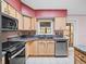 Kitchen with stainless steel appliances and wood cabinets at 5004 Saint Andrews Arc, Leesburg, FL 34748