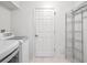 Laundry room with washer, dryer, and shelving unit at 5004 Saint Andrews Arc, Leesburg, FL 34748