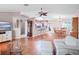 Open living space with hardwood floors, a view of the kitchen, and a dining area at 5004 Saint Andrews Arc, Leesburg, FL 34748