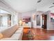 Living room with hardwood floors, large windows, and a comfortable sofa and chair at 5004 Saint Andrews Arc, Leesburg, FL 34748