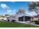 Tan house with screened porch and landscaped yard at 5622 King James Ave, Leesburg, FL 34748