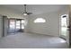 Bright living room with gray carpet, ceiling fan, and sliding glass doors at 5622 King James Ave, Leesburg, FL 34748