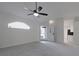 Bright living room with gray carpet, ceiling fan, and access to kitchen at 5622 King James Ave, Leesburg, FL 34748
