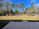 Large backyard with patio, fenced in, and mature trees at 61 Fir Dr, Ocala, FL 34472