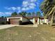 One-story house with brown garage door and landscaped lawn at 61 Fir Dr, Ocala, FL 34472