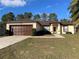 Front view of a single story house with a brown roof at 61 Fir Dr, Ocala, FL 34472
