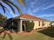 Beautiful backyard with manicured landscaping, spacious lawn, and screened in patio at 752 Maybank Loop, The Villages, FL 32162