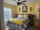 Cozy bedroom with a ceiling fan, large window, and cheerful yellow walls at 752 Maybank Loop, The Villages, FL 32162