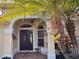 Charming front entrance featuring an arched portico, double doors, side lights, exterior lighting, and brick paver walkway at 752 Maybank Loop, The Villages, FL 32162