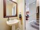 Small powder room with pedestal sink and mirror at 765 Walkers Grove Ln, Winter Garden, FL 34787