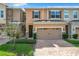 Townhouse exterior featuring two-car garage and landscaped front yard at 765 Walkers Grove Ln, Winter Garden, FL 34787