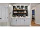 Built-in coffee bar with white cabinets and shelving at 8801 Village Green Blvd, Clermont, FL 34711