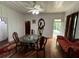 Elegant dining room features hardwood floors, a unique glass-top table, and an ornate mirror at 110 N Volusia Ave, Pierson, FL 32180