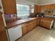 Kitchen boasts wood cabinets, tile countertops, and a built-in dishwasher at 110 N Volusia Ave, Pierson, FL 32180