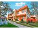 Condo building with orange accents and lush landscaping at 1112 W Main St # E7, Leesburg, FL 34748