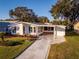 Single-wide mobile home with covered carport at 1121 Paradise Dr, Lady Lake, FL 32159