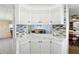 Modern kitchen features white cabinets, marble countertops, and gray tile backsplash at 12 Hilly Way, Fruitland Park, FL 34731