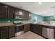 Modern kitchen with dark cabinets and granite countertops at 12066 Callicarpa Ln, Leesburg, FL 34788