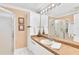 Bathroom featuring a granite countertop, white cabinets, and a walk-in shower, providing a functional and inviting space at 1228 Zapata Pl, The Villages, FL 32159