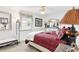 A cozy bedroom features a large window, ceiling fan, white trim and classic design elements at 1228 Zapata Pl, The Villages, FL 32159