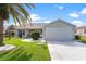 Single-story home with gray siding, attached garage, and well-manicured lawn at 1228 Zapata Pl, The Villages, FL 32159