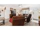 Cozy living room featuring comfortable leather furniture, a ceiling fan, and ample natural light through the window at 1228 Zapata Pl, The Villages, FL 32159