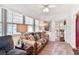 A bright living room features large windows, ceiling fan and comfortable seating at 1228 Zapata Pl, The Villages, FL 32159