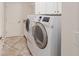 Functional laundry room equipped with modern, front-load washer and dryer units, plus cabinet storage at 1257 Eureka Mill Run, The Villages, FL 32162