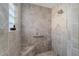 Walk-in shower featuring tile surround, a built-in bench, showerhead, and grab bar for accessibility at 1257 Eureka Mill Run, The Villages, FL 32162