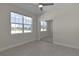 Bedroom with mirrored closet doors and large windows at 12624 Ne 49Th Dr, Oxford, FL 34484