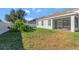 Private backyard with screened patio, grassy area, and white vinyl fence at 15836 Starlite St, Clermont, FL 34714