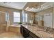 Bathroom with double vanity, granite countertop, soaking tub and shower at 15836 Starlite St, Clermont, FL 34714