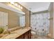 Clean bathroom with double vanity and seashell shower curtain at 15836 Starlite St, Clermont, FL 34714