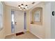 Bright entryway with a white door, mirror, and chandelier at 15836 Starlite St, Clermont, FL 34714
