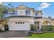 Two-story house with a white exterior, landscaping, and a two-car garage at 15836 Starlite St, Clermont, FL 34714