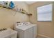 Bright laundry room with washer, dryer, utility sink and shelving for storage at 15836 Starlite St, Clermont, FL 34714