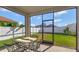 Screened-in porch with a table and chairs, overlooking a grassy backyard at 15836 Starlite St, Clermont, FL 34714