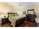 Bedroom with floral bedding and dark wood furniture at 17112 Se 71St Lewisfield Ter, The Villages, FL 32162