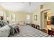 Spacious bedroom with striped bedding, seating area, and ensuite bathroom access at 17112 Se 71St Lewisfield Ter, The Villages, FL 32162