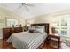 Bright bedroom with striped bedding and wood flooring at 17112 Se 71St Lewisfield Ter, The Villages, FL 32162