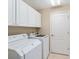 Laundry room with washer, dryer, and upper cabinets at 17112 Se 71St Lewisfield Ter, The Villages, FL 32162